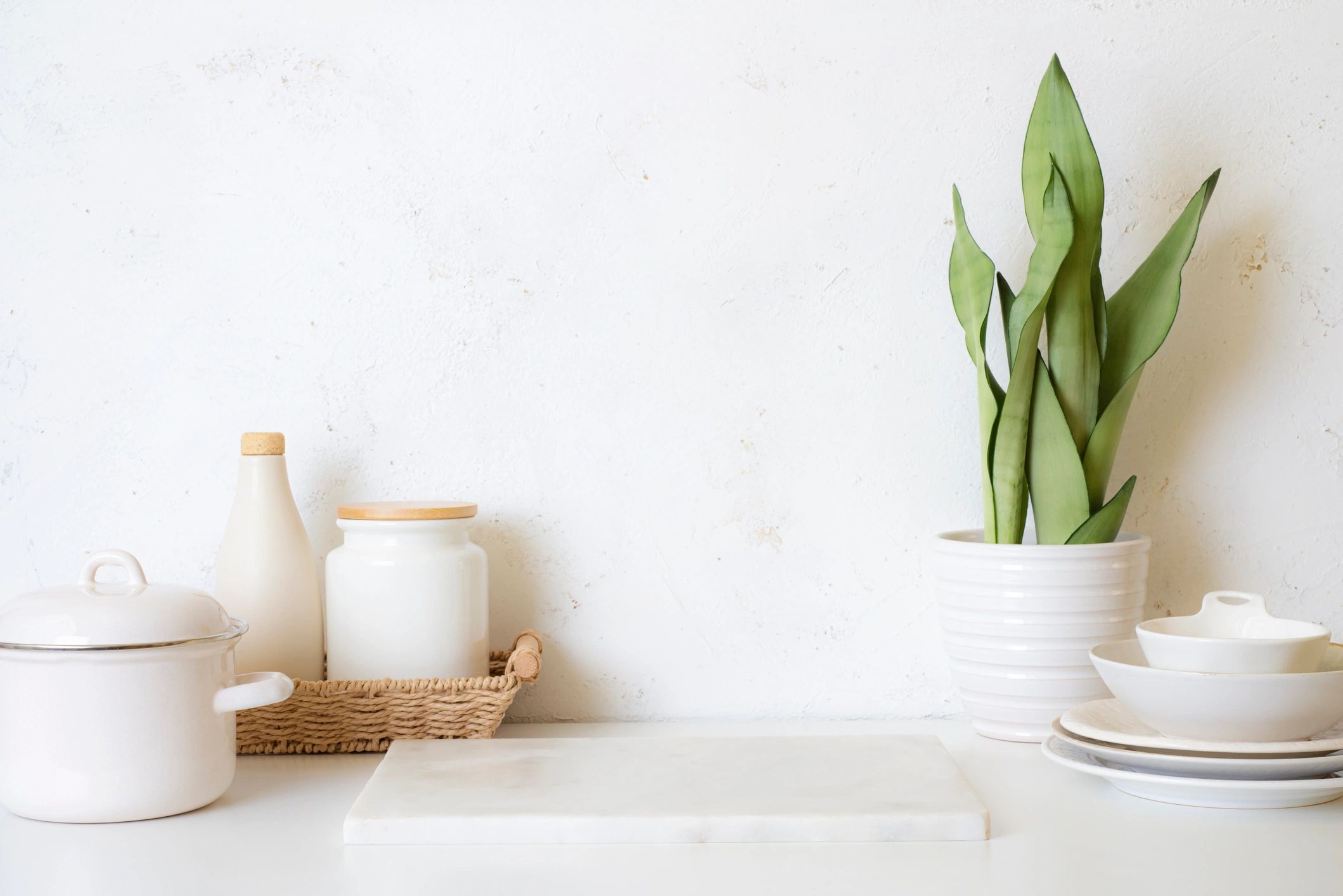 Kitchenware display with utensils and cookware on a marble kitchen table