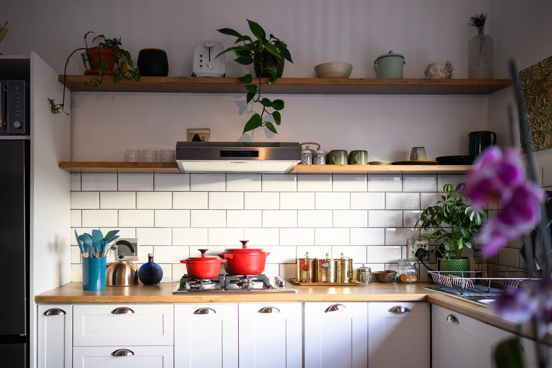 Bright modern kitchen with cookware and white cabinets